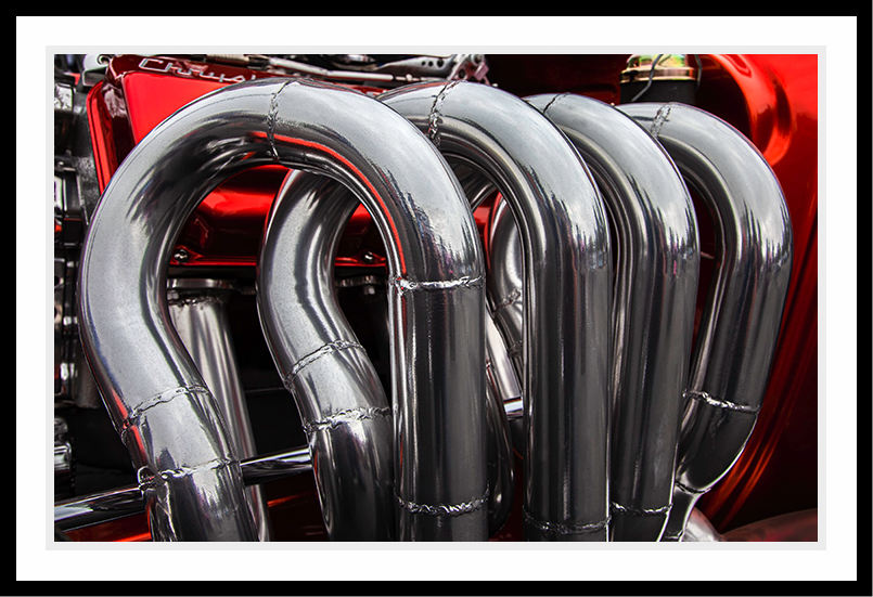 Sliver looking tubes on a car engine.